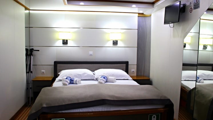 a large grey bed against an illuminated white wall aboard the prestige luxury mediterranean yacht