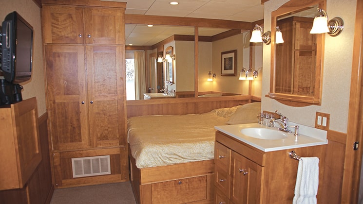 single cabin with bed, desk and large mirror aboard the Safari Explorer Hawaii small ship