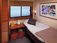 Safari Voyager panama small ship single cabin with bed, picture above the bed and 2 windows