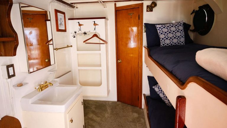 Twin bunk beds, sink, mirror, porthole in Stateroom 6 aboard Sea Wolf yacht in Alaska