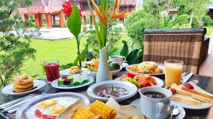 A table with a full breakfast layout at Toraja Misilliana Hotel.