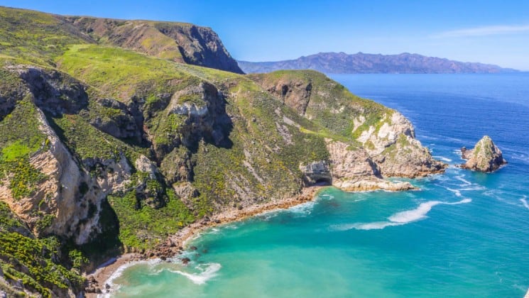aerial of secluded bay with turquoise water and large cliffs in channel islands