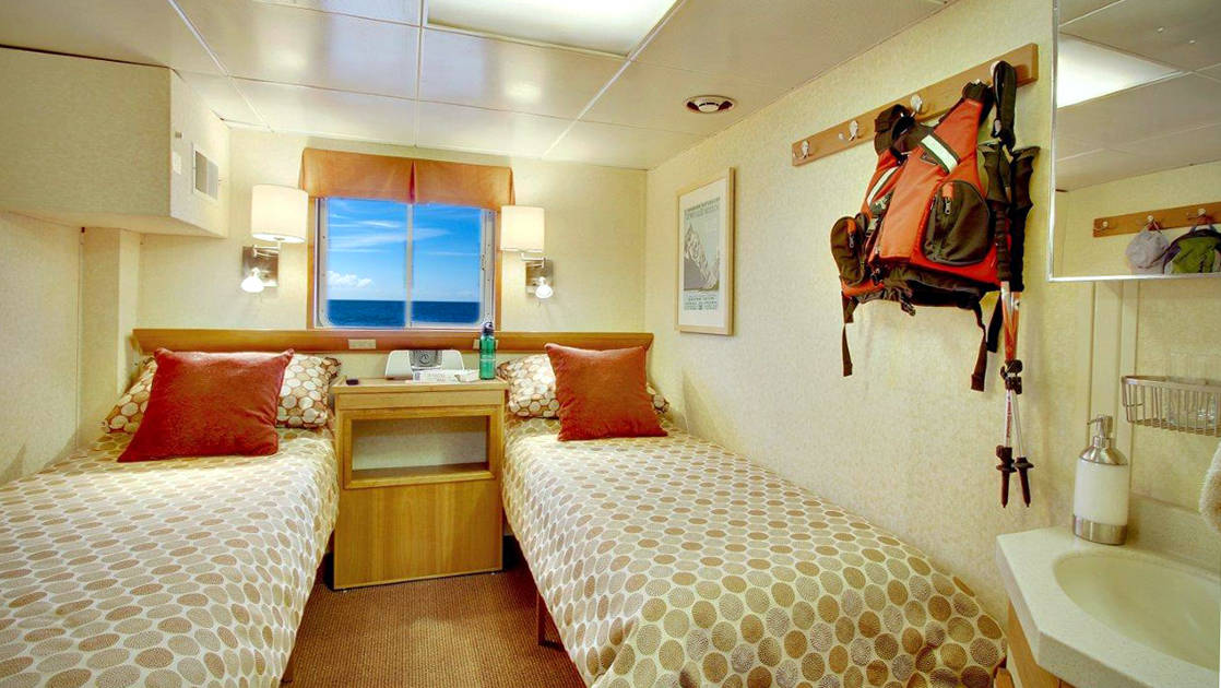 Trailblazer cabin with twin beds and window aboard Wilderness Discoverer