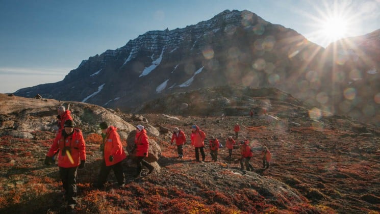 a group of people hike across the tundra in the arctic circle