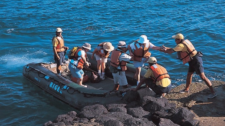 Guests at La Pinta cruise ship disembark from a motored raft for a full-day of wildlife viewing at the Galapagos Islands