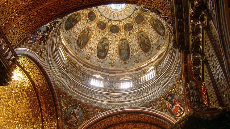 looking up at the inside of an ornate basilica dome on the quito and guayaquil galapagos land tour
