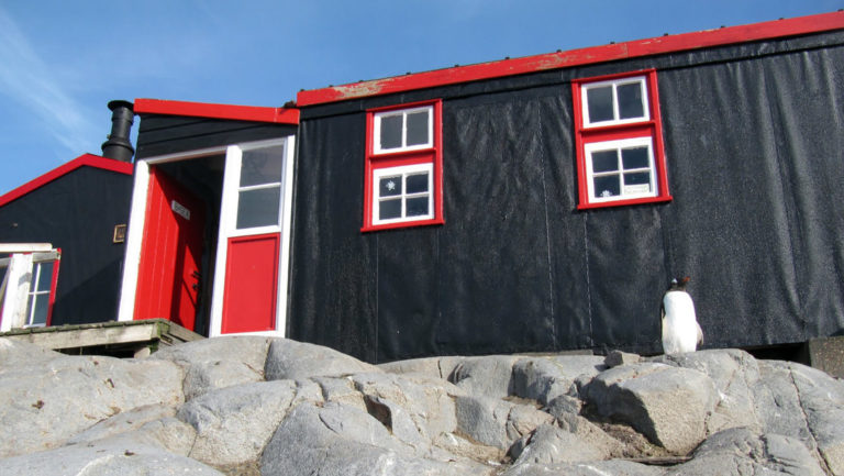 port lockroy antarctica building with black paint and red trim on a sunny day