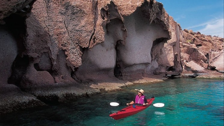 kayaker beside cliff on baja: a remarkable journey cruise