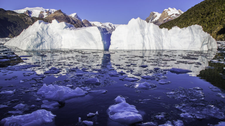 Floating ice in front of a glacier in Chile with mountains in the background