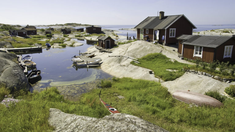 Several small houses and boats on various islands surrounding the Stockholm archipelago