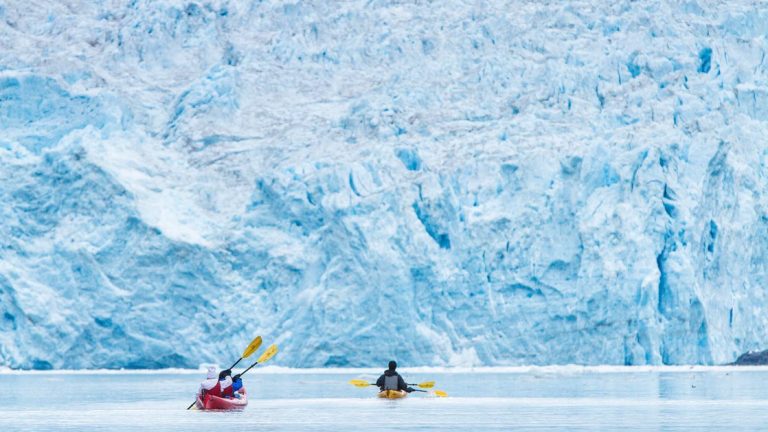 Two kayaks on the open water of the Kenai National Park in front of a glacier in Alaska where the backcountry shines the brightest