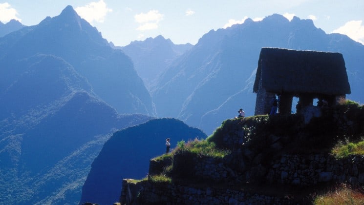 cliffside stone hut surrounded by the mountains of peru seen on machu picchu explorer land tour