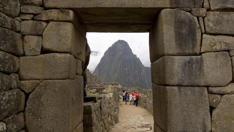 travelers explore machu picchu with mountains in background