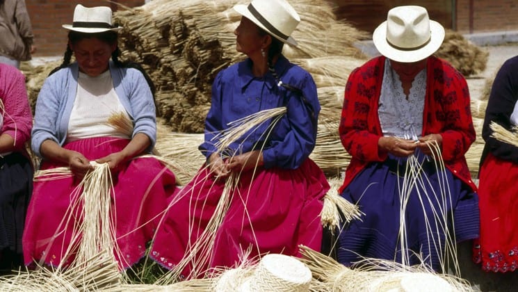 local women wearing panama hats weave straw on otavalo escape ecuador land tour