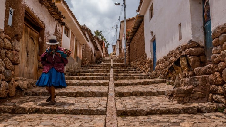 older woman descending cobblestone steps on peru highlights trip