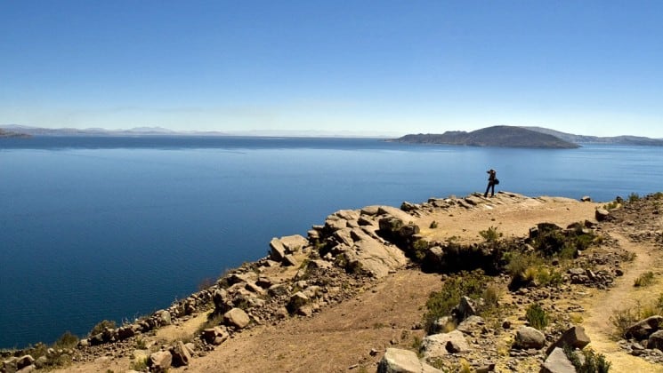 wide view of lake titicaca and photographer on peru land tour