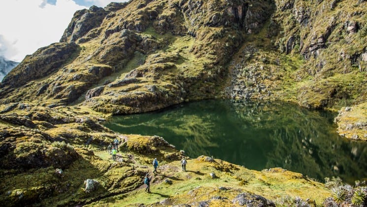 trekkers approach a mountain pond on sacred valley & lares adventure to machu picchu