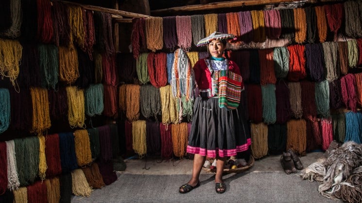 local peruvian woman showing samples in textile shop on sacred valley & lares adventure to machu picchu
