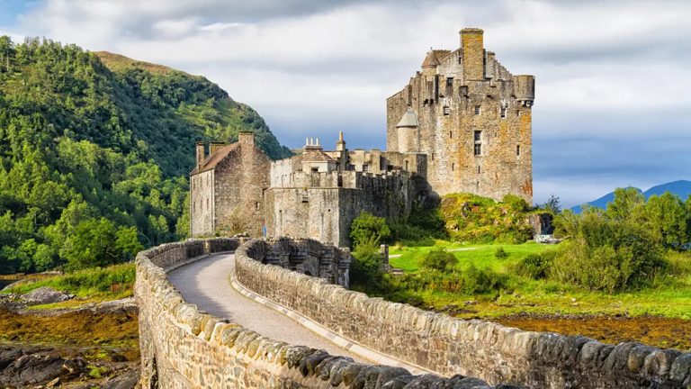 a stone castle in ireland with green landscape surrounding