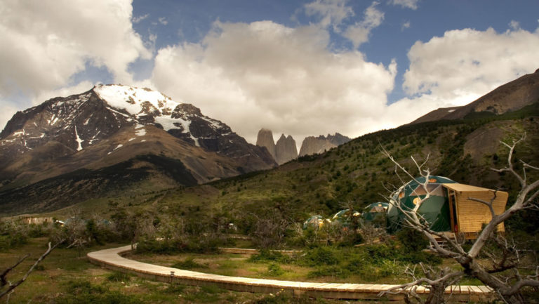 Boardwalk path to several glamping domes at the Patagonia Eco camp surrounded by mountains in chile