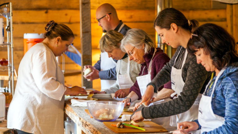 small group in a cooking class with the chef at tutka bay lodge in alaska