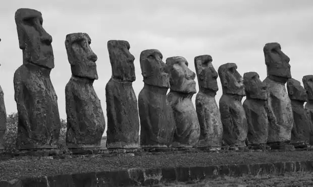 A line up of Moai Statues in black and white.