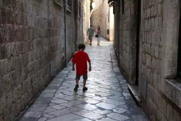 Child walking down marble alleyway in Dubrovnik Croatia. 