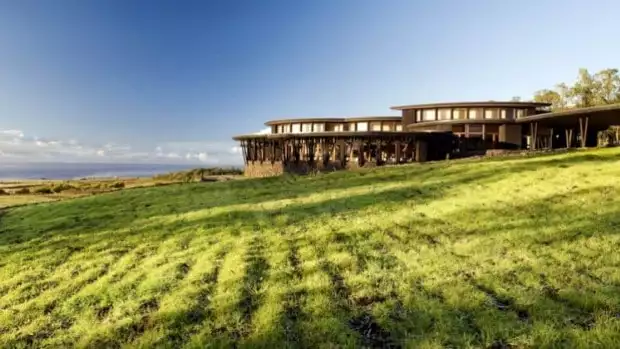 Explora Rapa Nui lodge with green grass in front of the lodge looking out over the ocean and landscape.