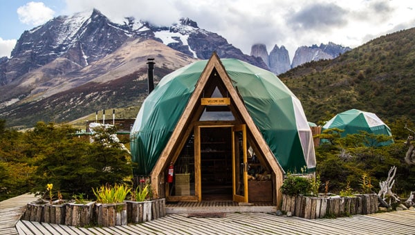 Dome adventure lodge in Patagonia with green roof and A-frame entrance