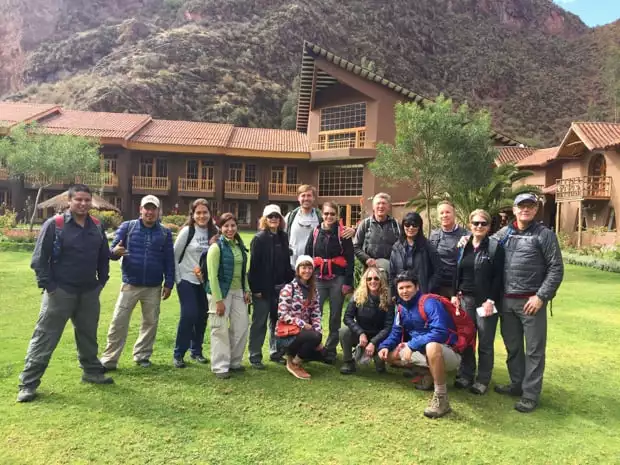 Group of travelers posing in front of a lodge on a land tour in Peru.