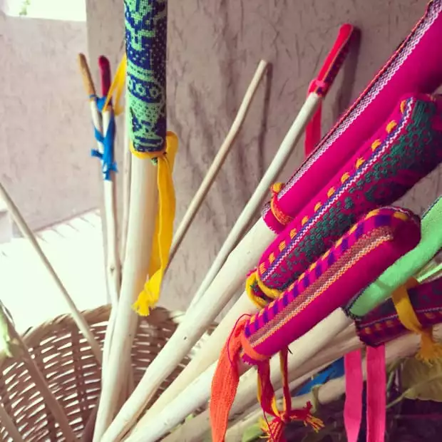 Eucalyptus hiking poles with colorful weaved textile as handles in a basket.