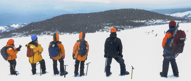 Group taking a break from their mountaineering excursion and looking at the view from where they climbed in Antarctica. 