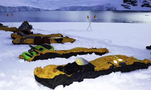 Bivy sacks lined up in the snow for camping excursion guests to sleep over night off their small ship in Antarctica. 