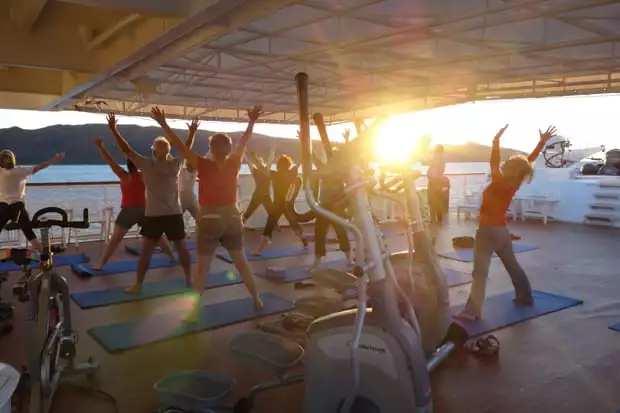 Morning Baja travelers doing yoga on the deck of a small ship cruise.