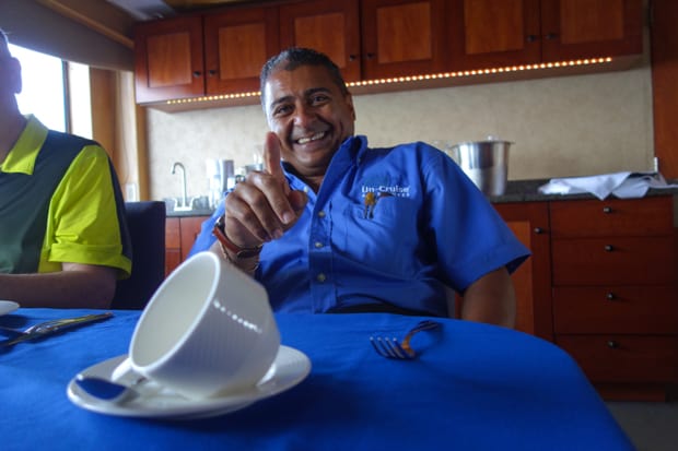 Uncruise small ship crew member relaxing at a table on the boat.