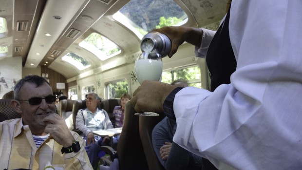 Guest enjoying a local pisco sour beverage made on the train ride to Aguas Calientes at Machu Picchu. 