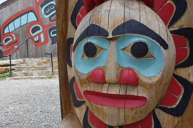 A totem of the sun with a face carved in the wood.