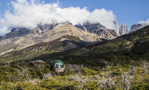 Dome ecocamps set on a hillside with snow capped mountains in the background of Torres del Paine.