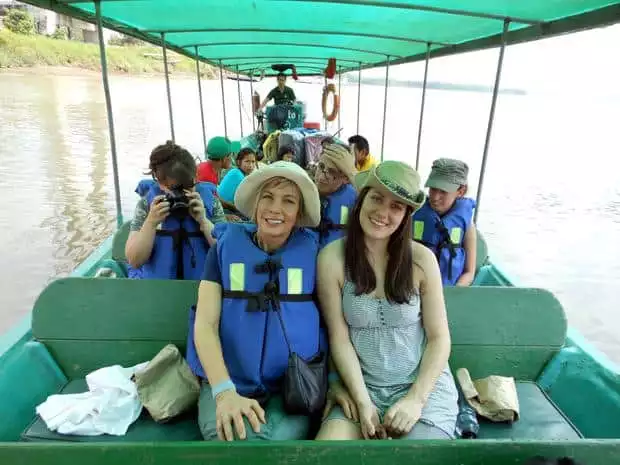 A group of travelers on a boat in the Amazon traveling on a river.