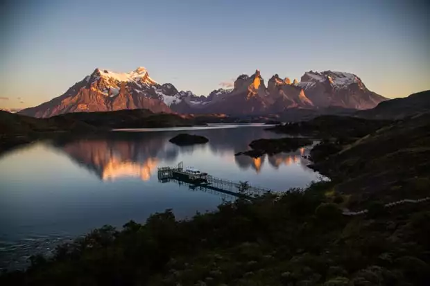Bird's eye view of a sunset of Lake Pehoe and the mountain range reflecting in the lake at Torres del Paine National Park.