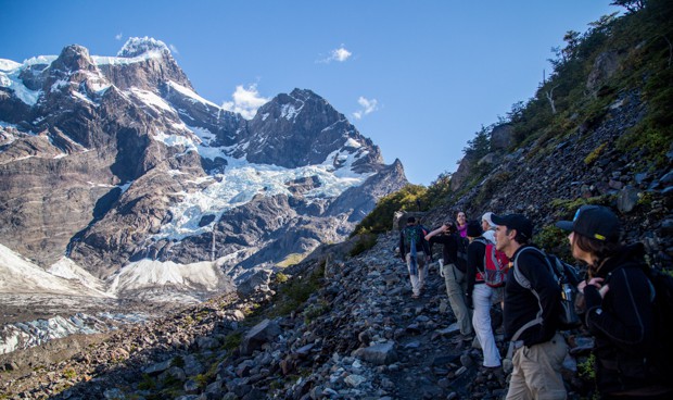 Travelers in Patagonia hiking along a rocky trail in Torres del Paine National Park.