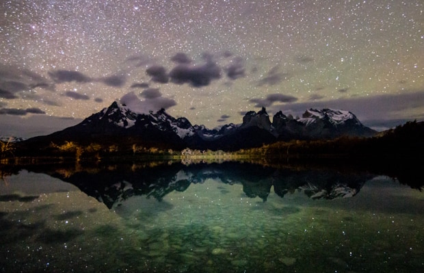 Night time photography with stars above Lake Pehoe and mountain range in Torres del Paine in Patagonia.