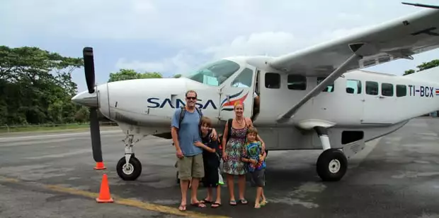 Family Travelers standing in front of a plane in Costa Rica