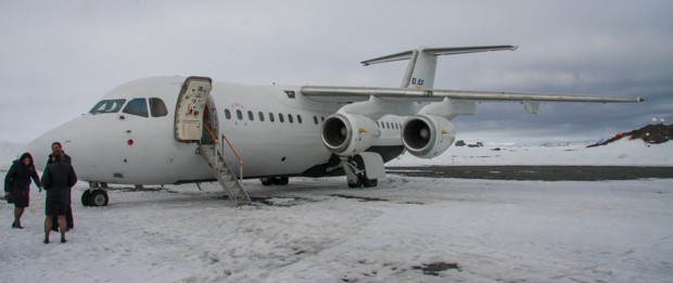 People getting on a plane on the snow in Antarctica. 