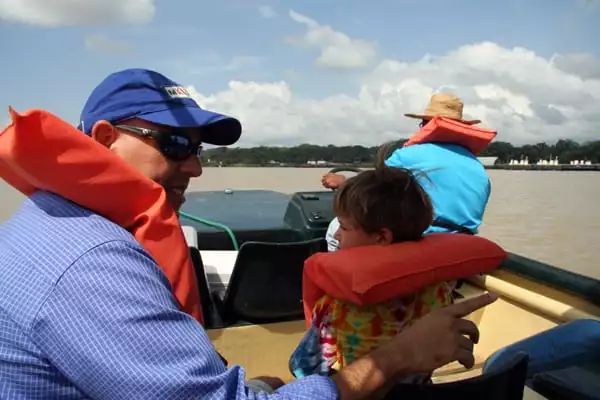 2 travelers and a guide cruising in a small boat in the Panama canal zone.
