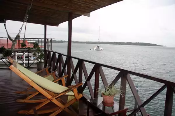 Bocas Inn view from the open air deck facing the ocean with a catamaran in the distance.