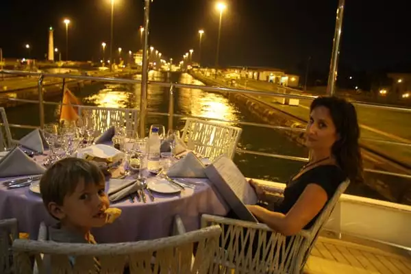 Family having dinner on the outside deck of their small ship cruising through the locks in the Panama Canal. 