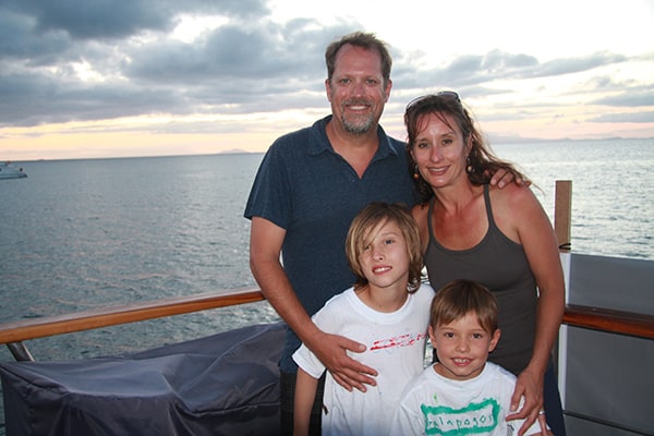 Happy family on the deck of the Coral I in the Galapagos at sunset.