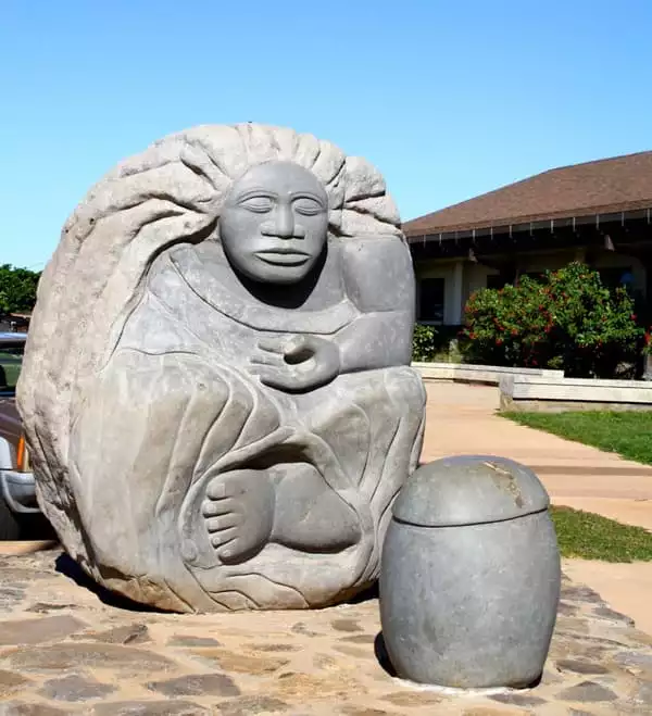 Hawaiian Hina statue carved into a large gray rock. Depicting a woman with long hair and eyes closed
