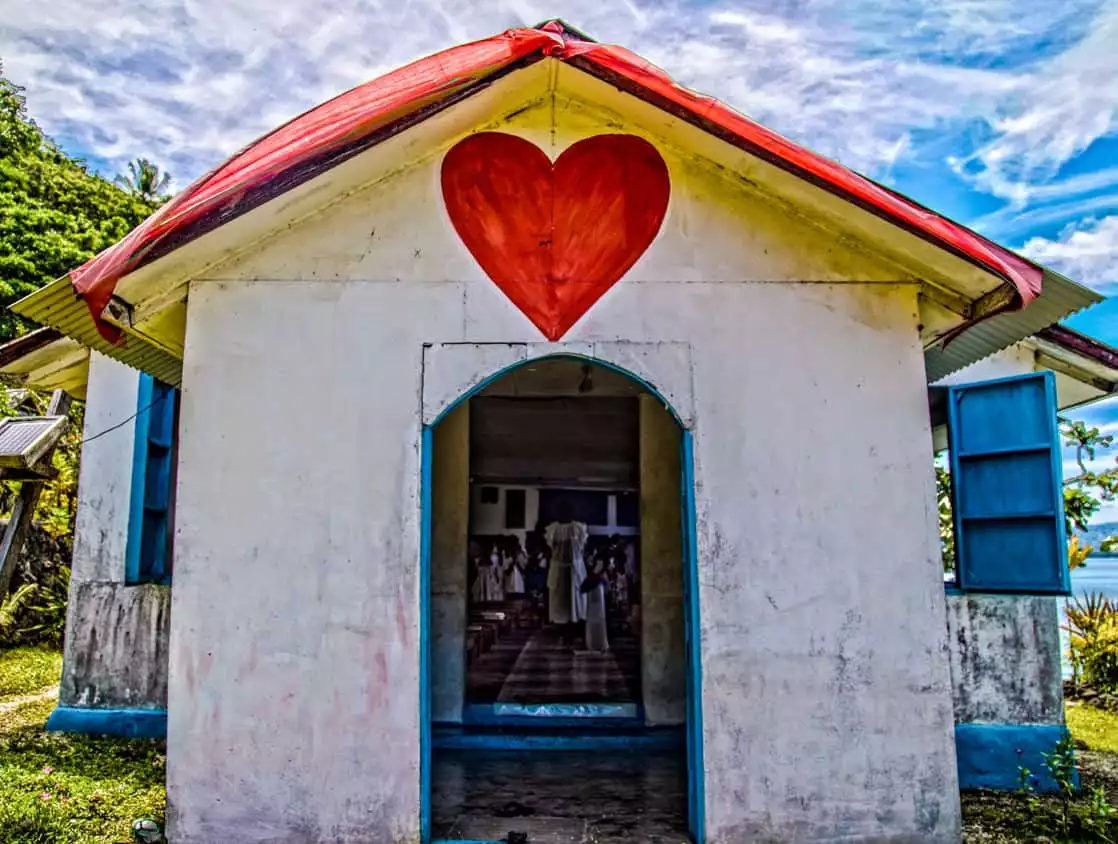 Small church with a red heart painted above the entrance on an island in the south pacific.